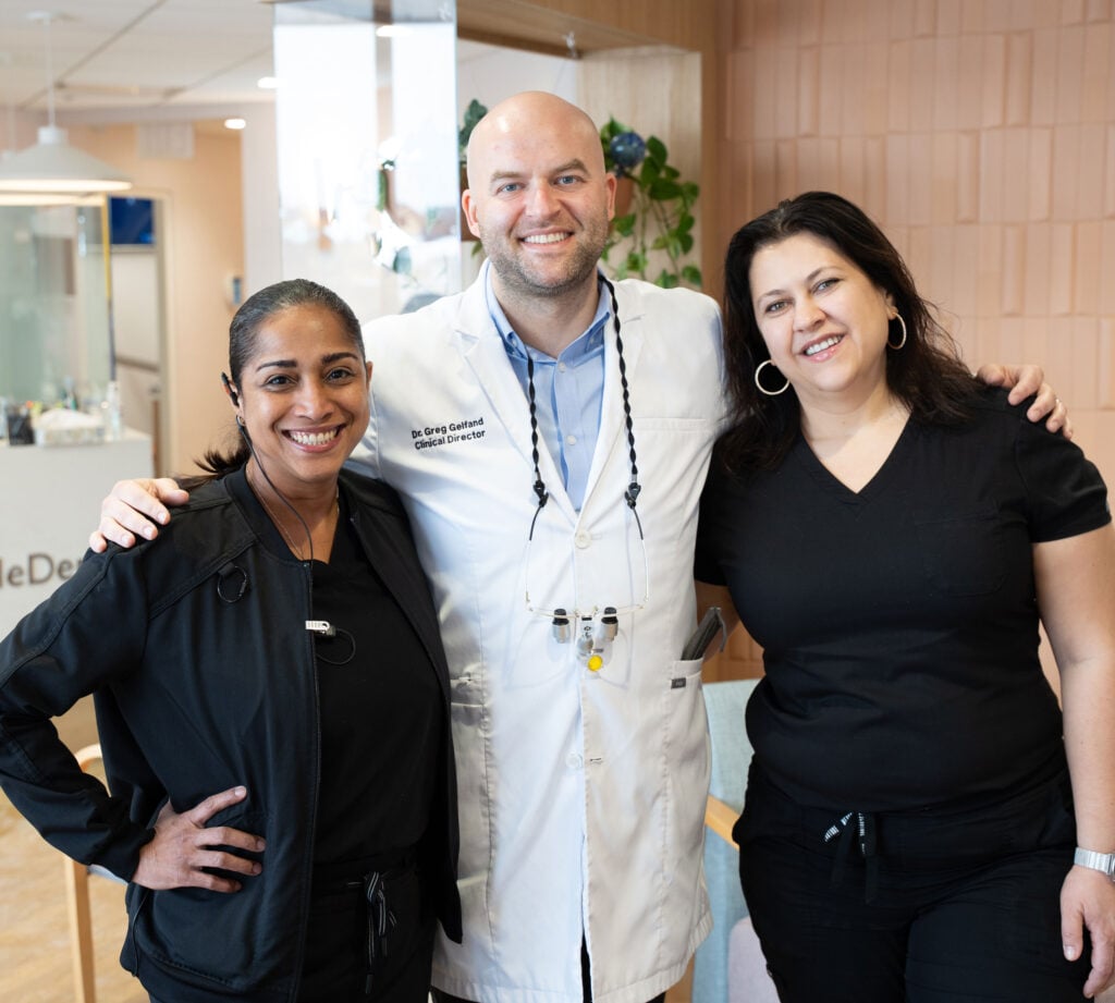 Dr. Greg Gelfand and dental staff smiling inside the Gentle Dental office reception area.